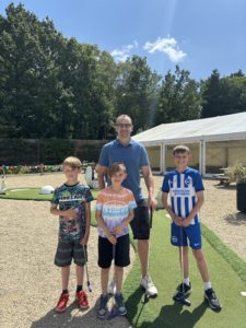 Family of 4 playing mini golf