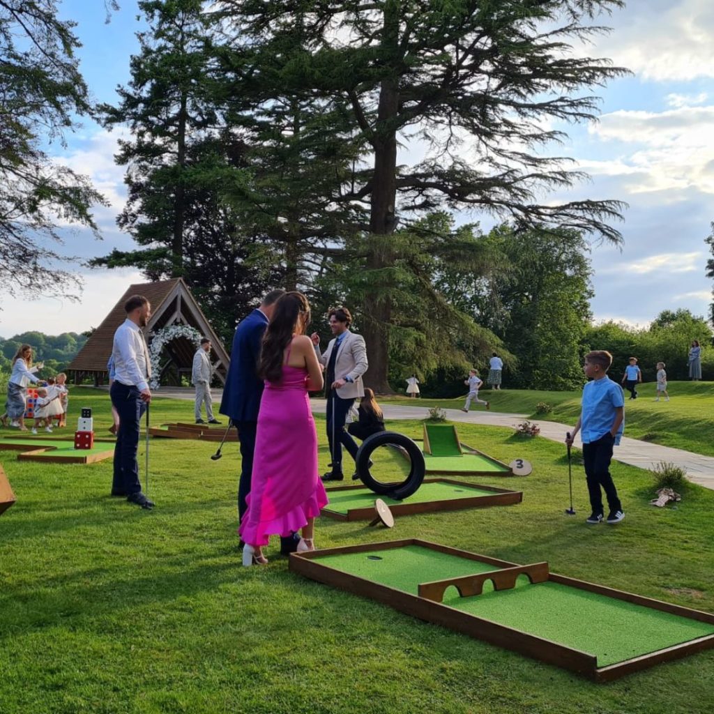 Guests at a wedding playing mini golf outdoors