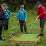 Boys playing crazy golf outdoors