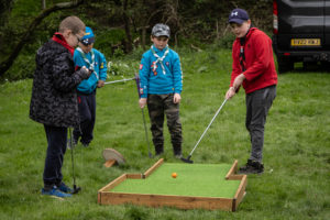 Boys playing crazy golf outdoors