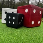 Three large wooden dice on a mini golf course