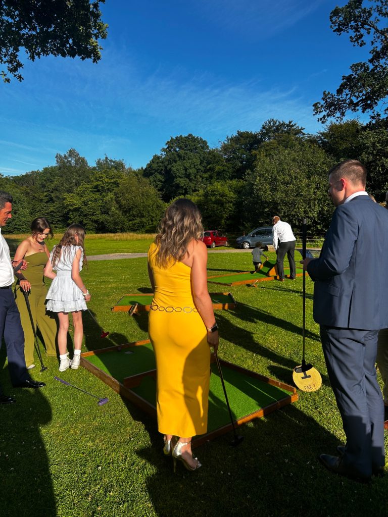 Couple playing mini golf at a wedding in summer