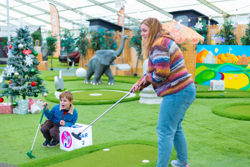 Mother and son playing mini golf