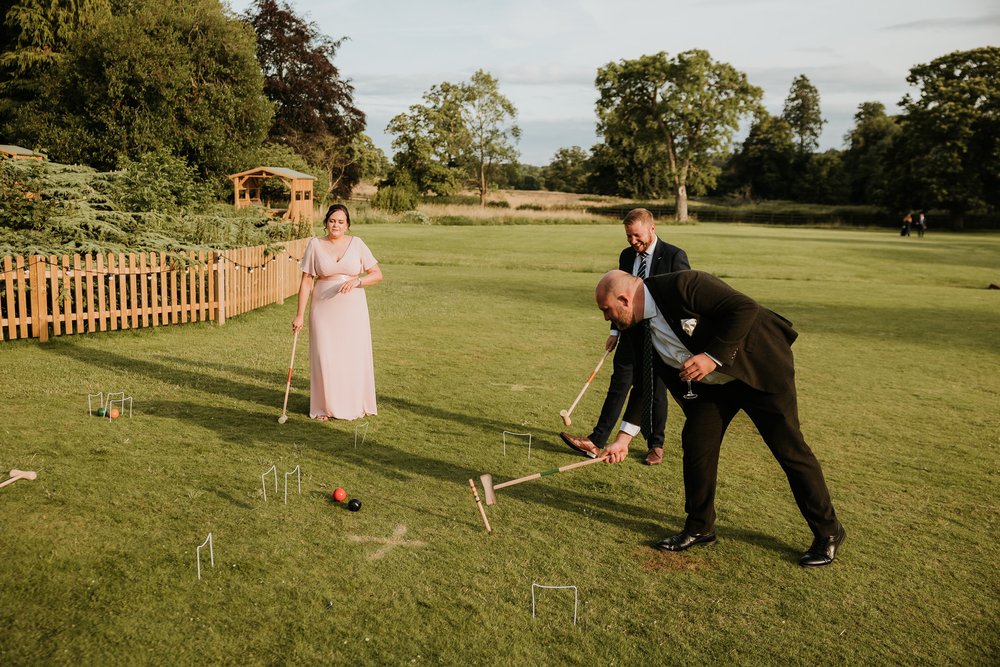 Wedding guests playing croquet