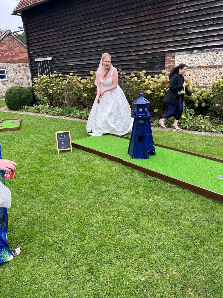 Bride in her wedding dress playing crazy golf