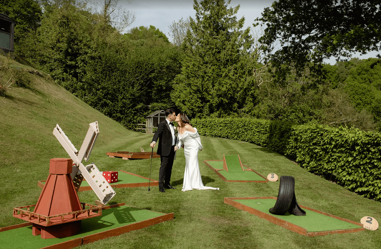Bride and groom kissing on a mobile mini golf course