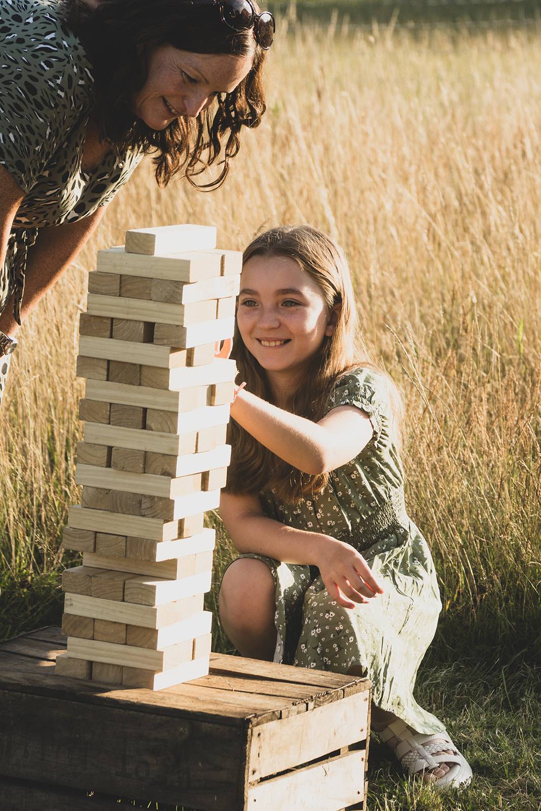 Girl playing game of giant jenga with an adult
