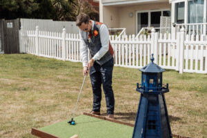 Wedding guest playing crazy golf with a lighthouse obstacle