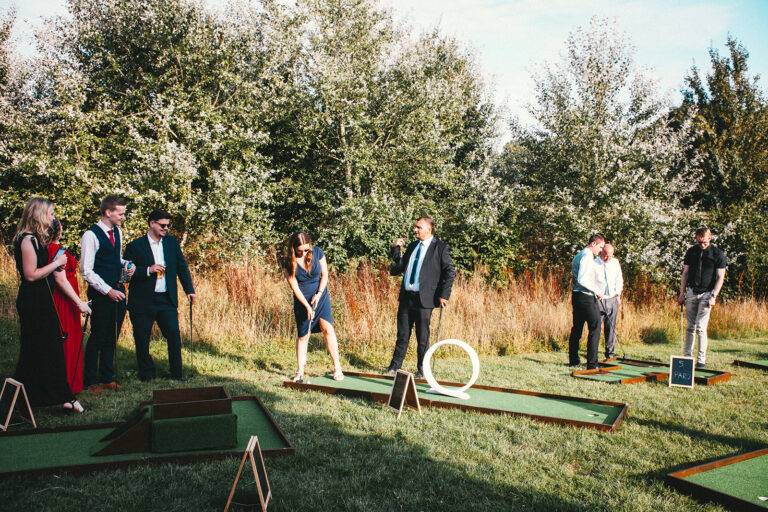 Outdoor mini golf at a wedding with guests playing