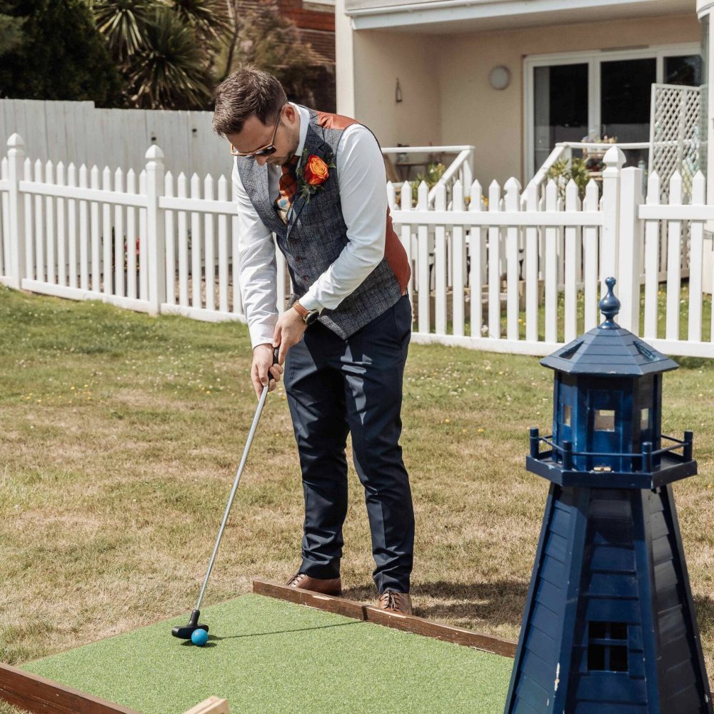 Wedding guest playing crazy golf with a lighthouse obstacle
