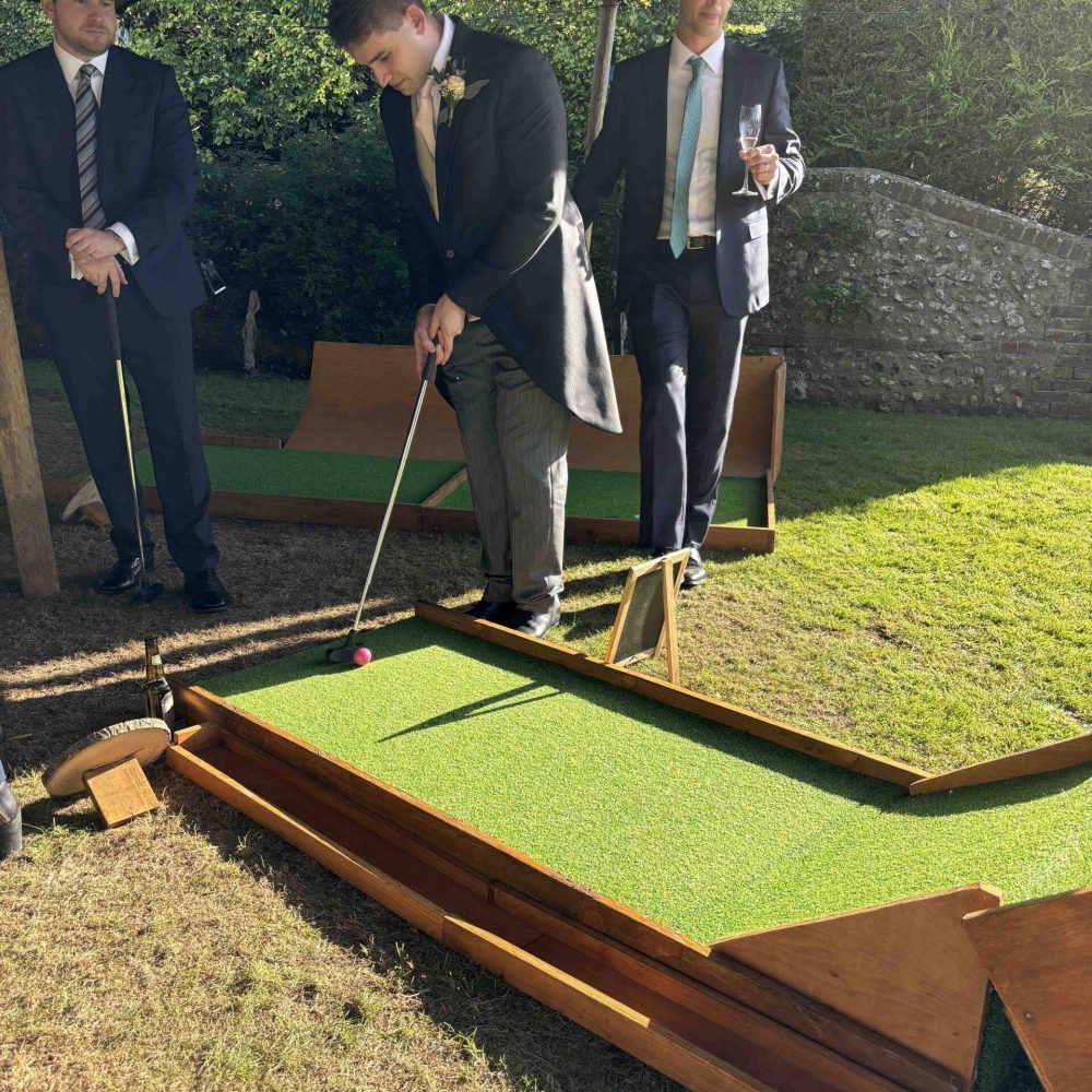 Man teeing up mini golf shot