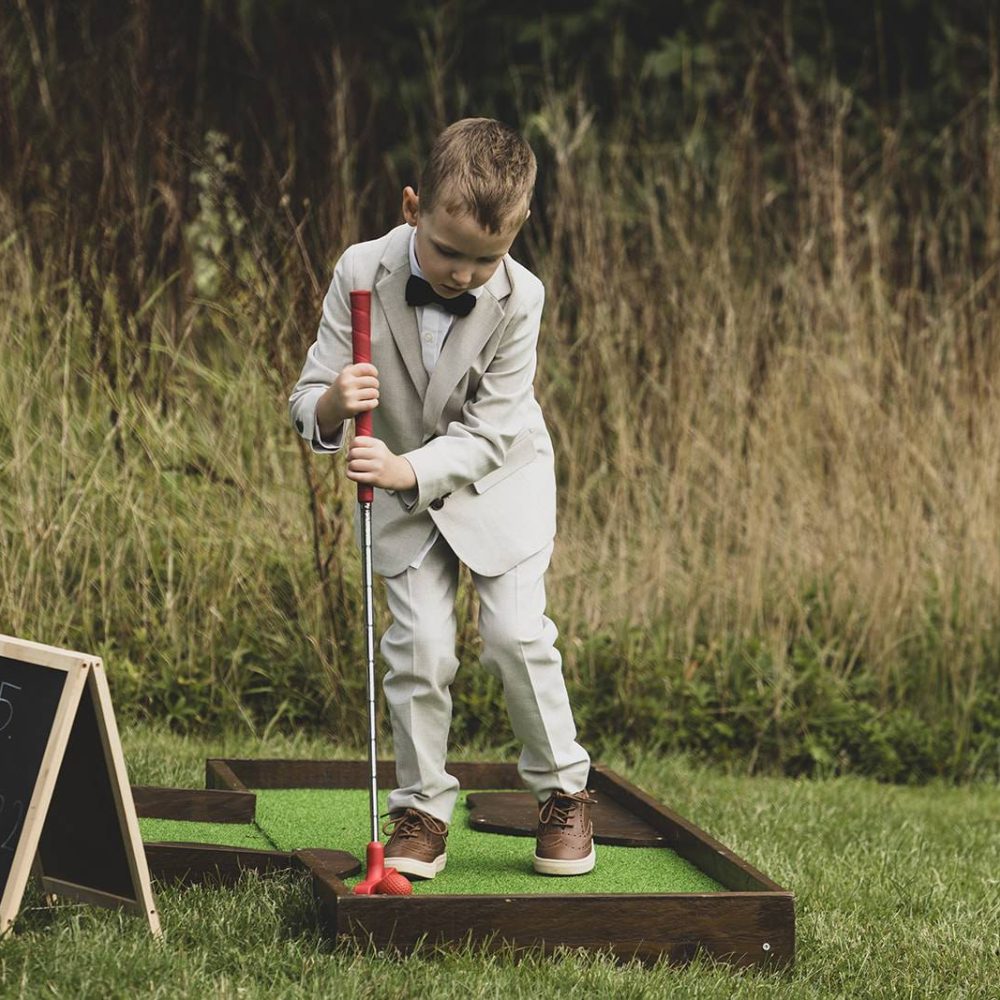 Boy playing crazy golf at a wedding